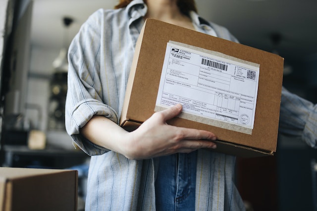 Person holding a package with a shipping label and barcode on it